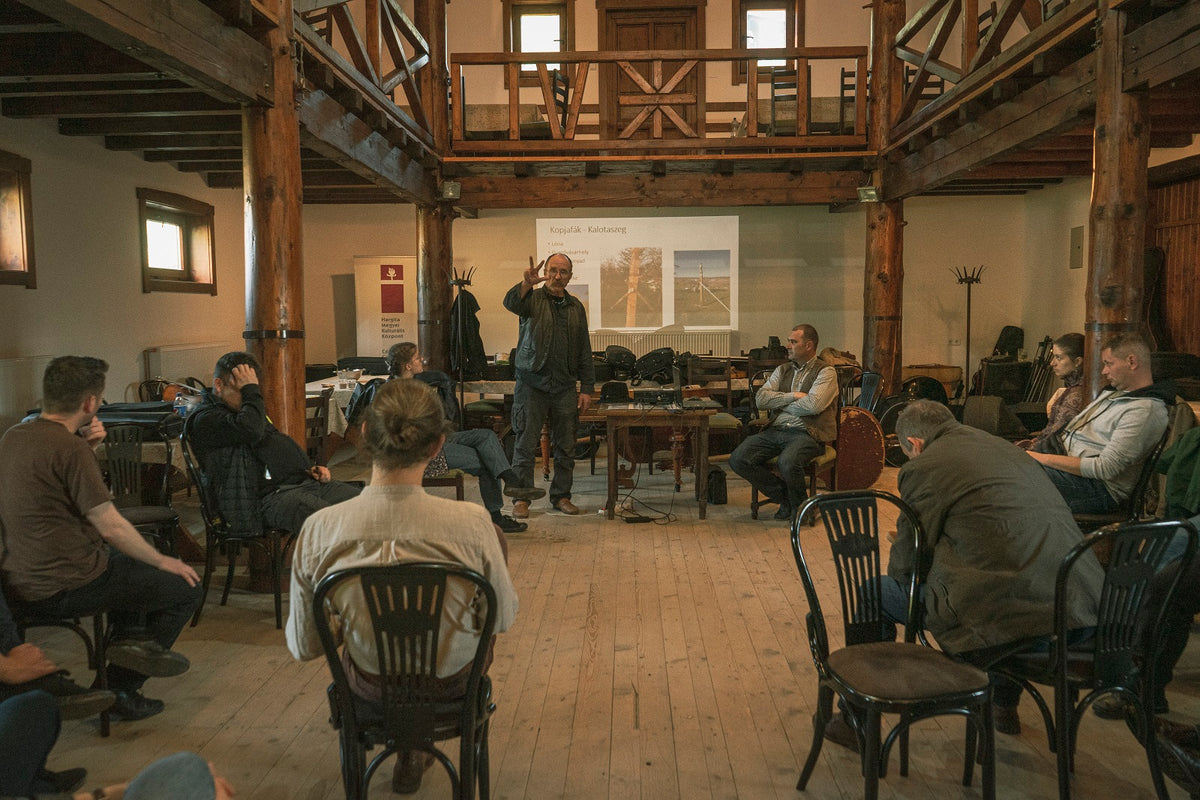 Folk musicians attending a workshop and discussion in a traditional timber hall.