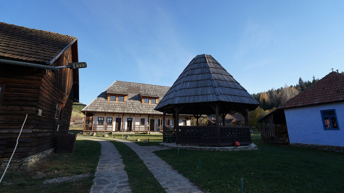 Csorja's gazebo and house seen together on a clear autumn day, along a stone path through the grounds.