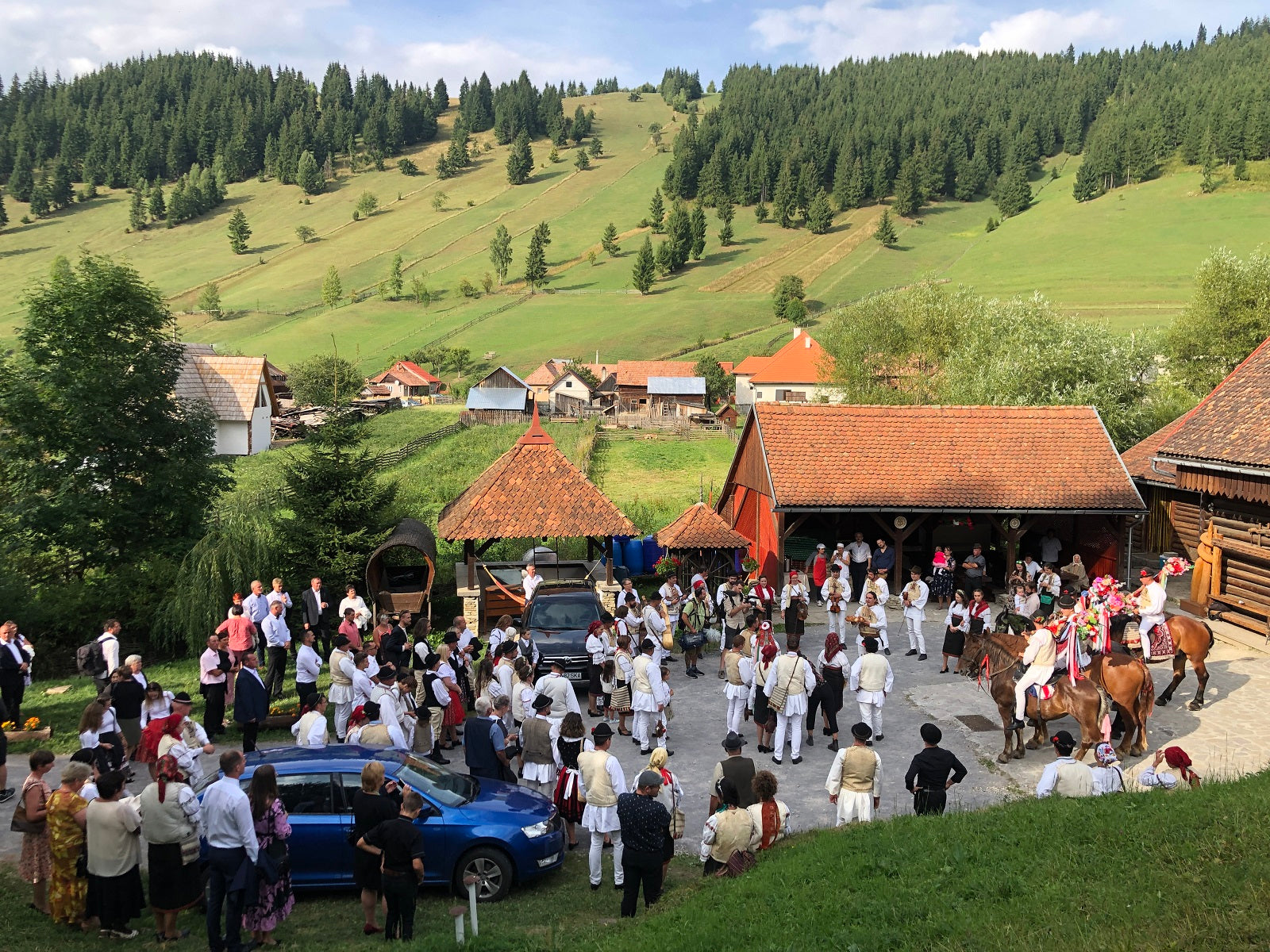 Wedding guests and horseback riders gathered outside the covered pavilion, musicians playing among the crowd.