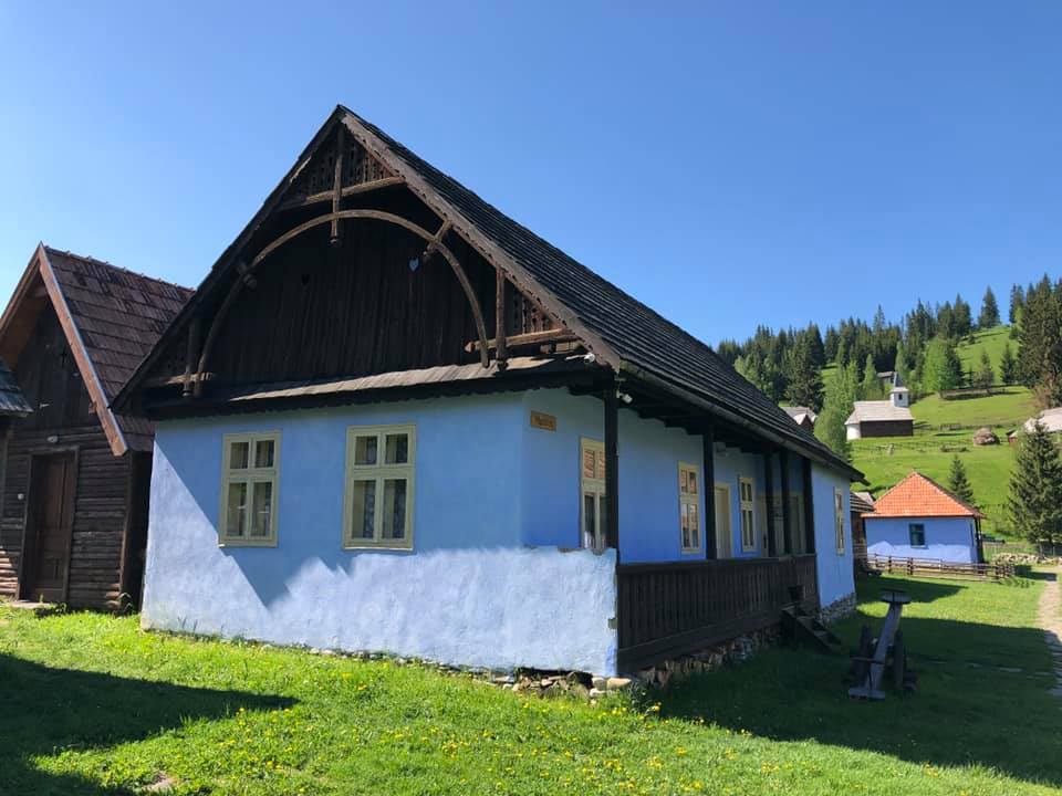 Madarasi house on a sunny day, showing its carved gable arch with a heart cutout above the porch.